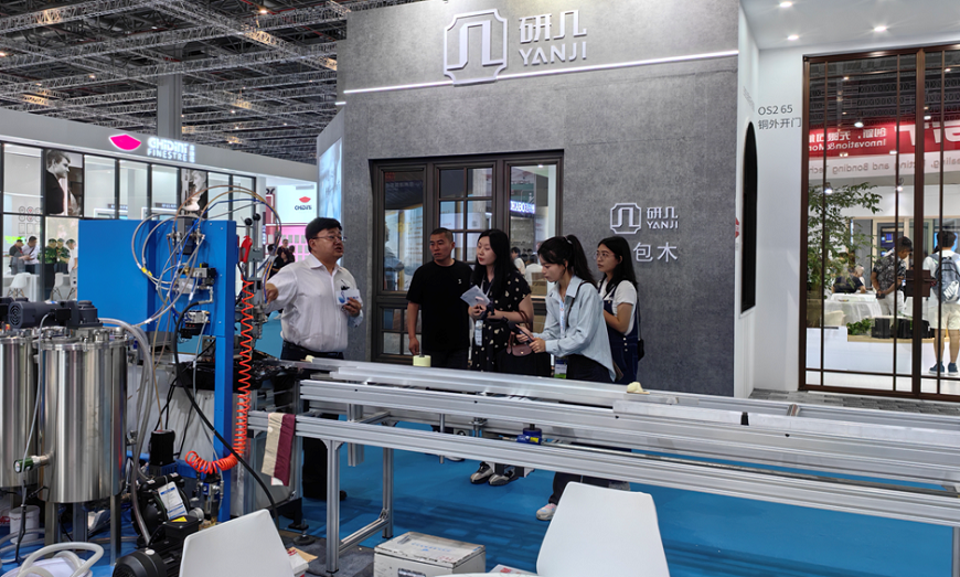 HGIT exhibition staff explaining the aluminum profile thermal barrier injection foaming equipment